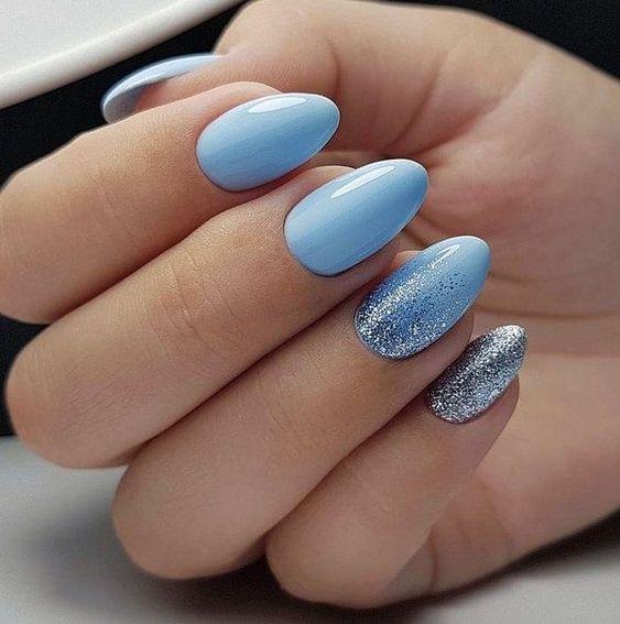 Woman wearing an elegant icy blue outfit with silver accessories, inspired by the Cool Blue Pinterest trend 2026.
